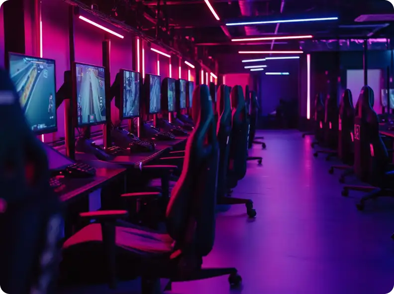 Rij gaming-pc's met verlichte toetsenborden en led-lichtstrips in een moderne esports-arena.