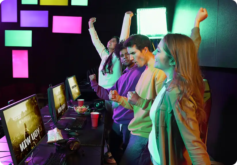 Opgewonden gamingteam reageert op een succesvolle wedstrijd in een kleurrijke, met neon verlichte gamingstudio.