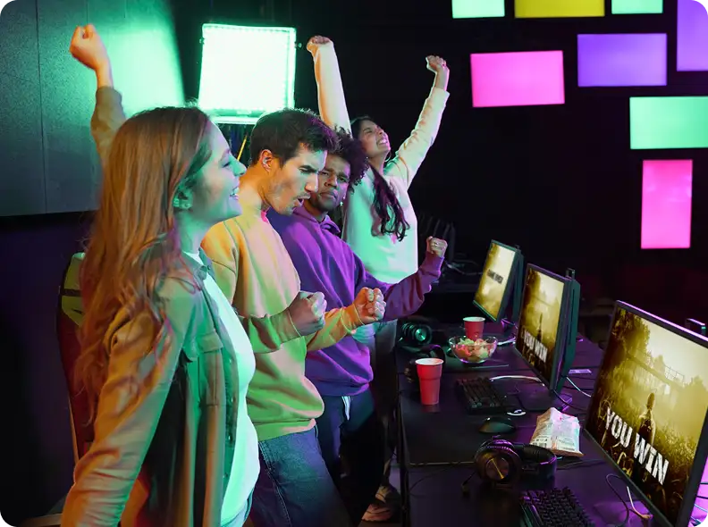 Opgewonden gamingteam reageert op een succesvolle wedstrijd in een kleurrijke, met neon verlichte gamingstudio.